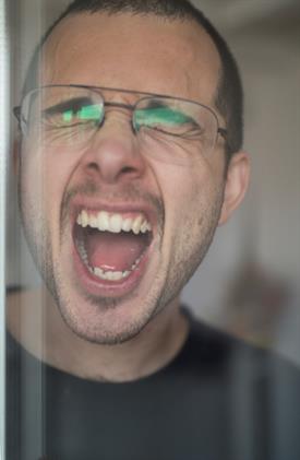 Close-up of a man who screams and pulls a face.